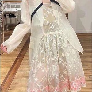 A charming silk and linen dress featuring cream and pink floral embroidery